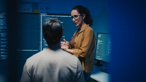 2 personnes devant des écrans d'ordinateur en réflexion