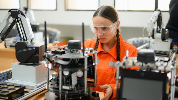 Une femme devant une machine avec des apapreils électroniques, des lunettes sur les yeux