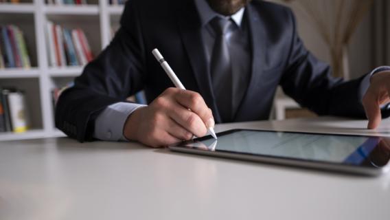 Homme d'affaire signant une tablette