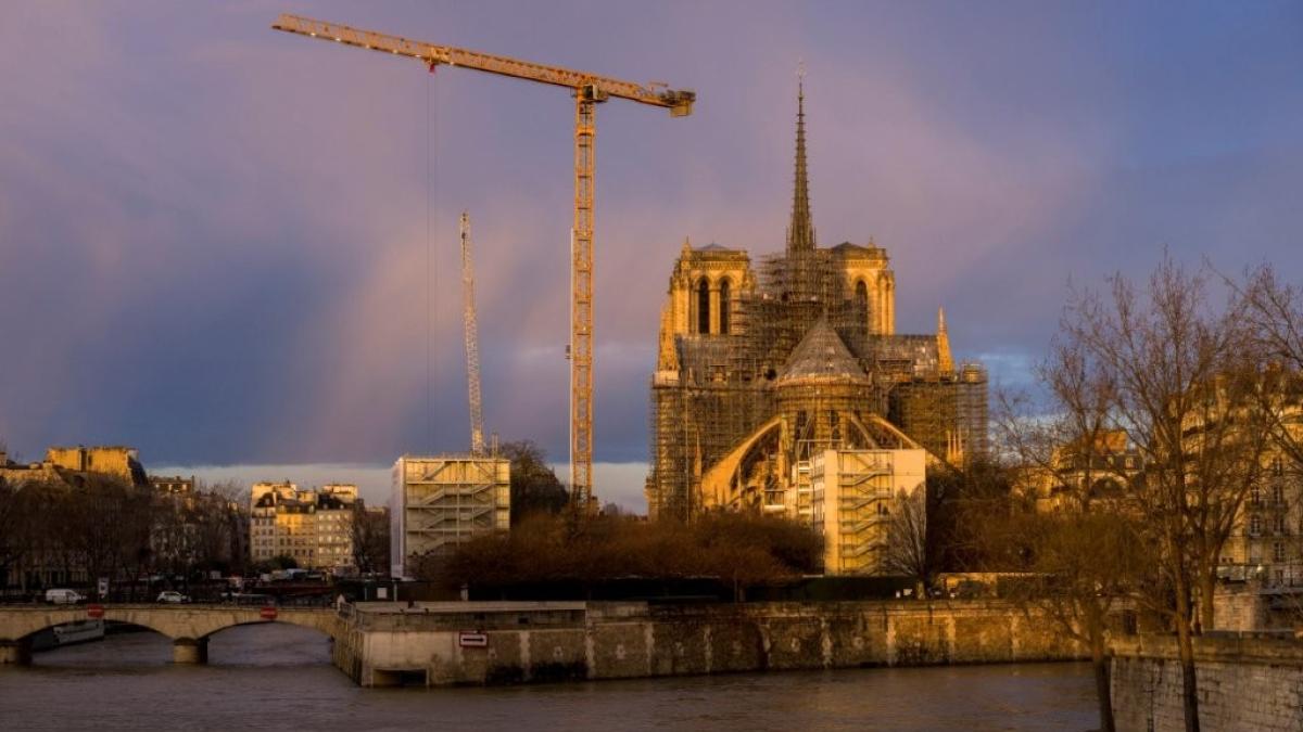 vue de la cathédrale notre dame de paris en chantier, avec une grue et des échafaudages