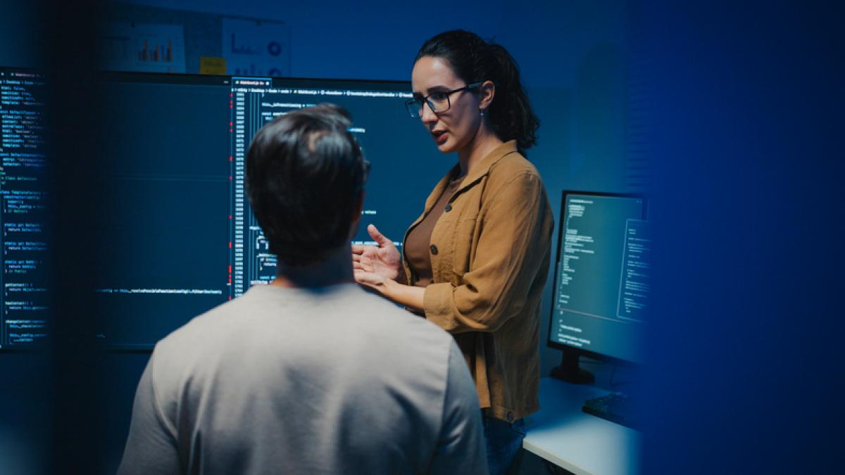 2 personnes devant des écrans d'ordinateur en réflexion