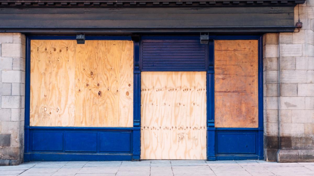 commerce dont les vitrines sont protégées de planches