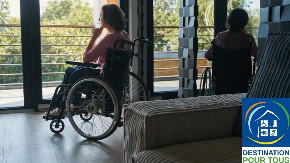 personne en fauteuil roulant devant une fenêtre et logo du label Destination pour tous