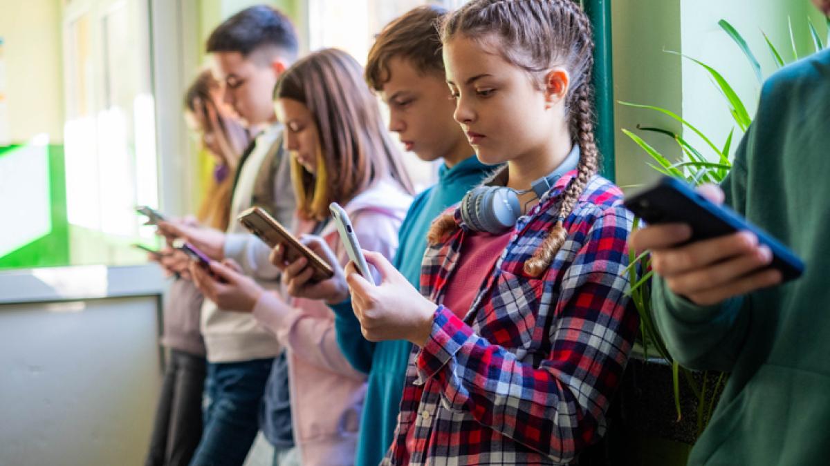 enfants tenant dans leurs mains un smartphone, tous concentrés sur leurs écrans